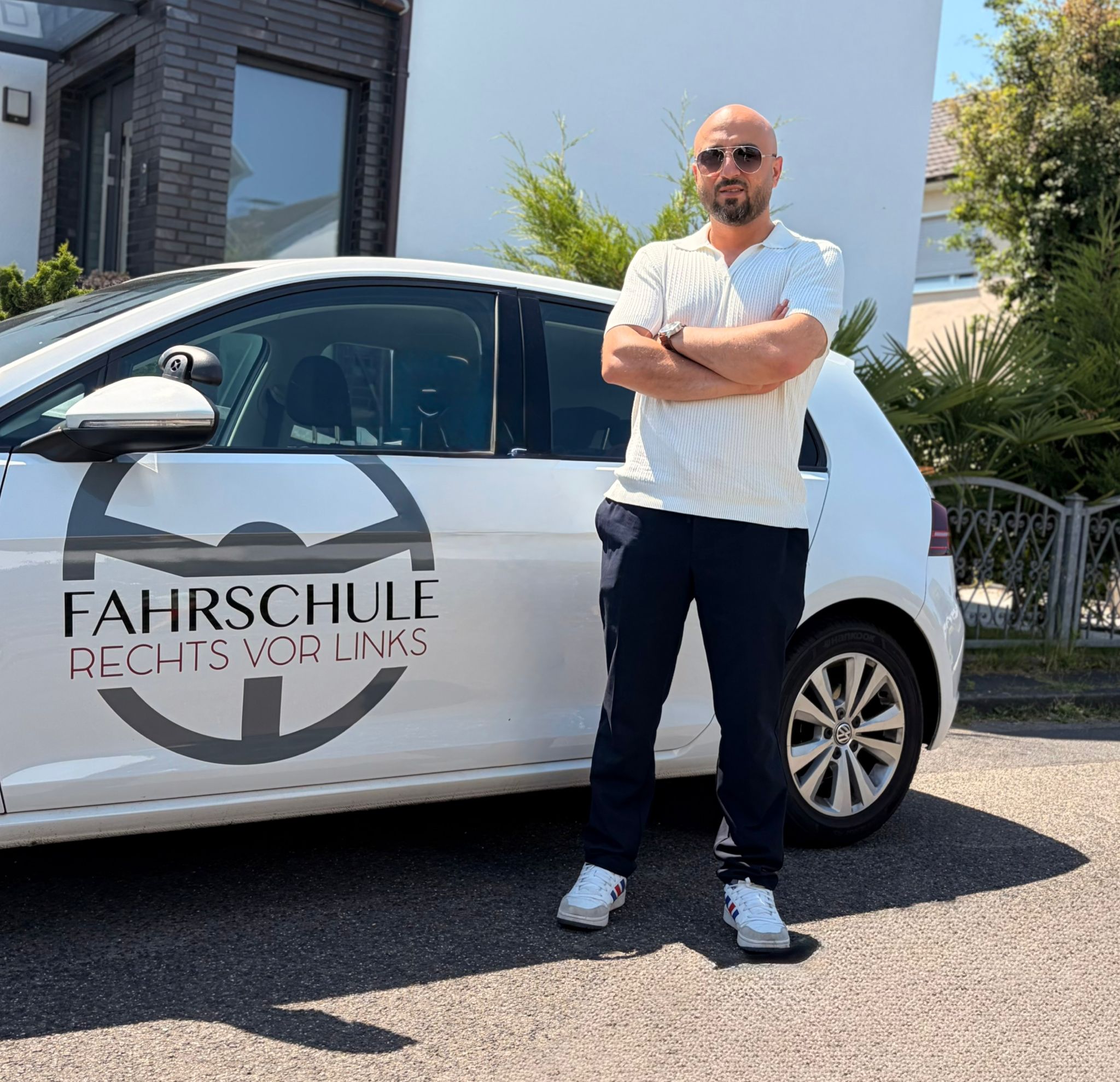 Fahrlehrer Ali vor dem Fahrschulauto